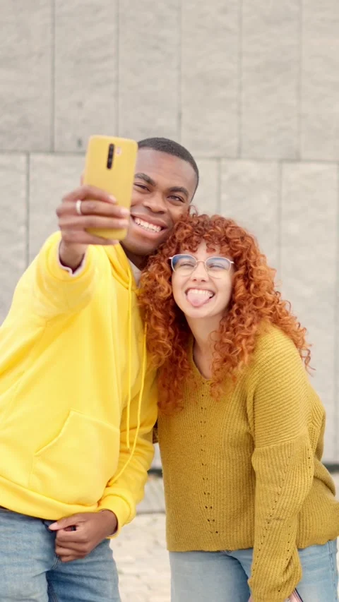 Young multiethnic couple taking a selfie on the street Stock Footage 261428731