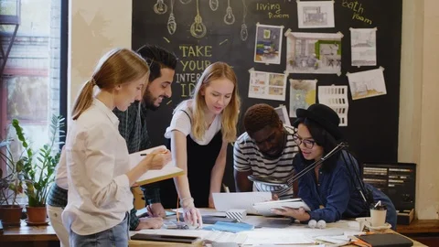 Young Multiethnic Designers Cooperating in the Office Stock Footage 115460676
