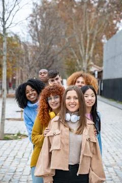 Young multiethnic friends smiling while posing standing in a row outdoors. 스톡 사진