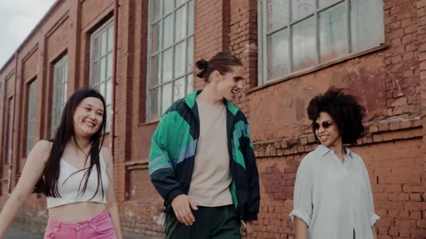 Young multiethnic group of friends actively chatting at the streets of old town Video stock 220723049