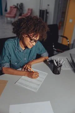 Young multiethnic lady making notes on document Foto stock