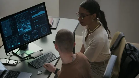 Young Multiethnic Programmers Discussing Work on PC in Night Office Stock Footage 292632402