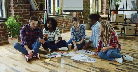 Young multiethnical workers of the startup company creating a business plan and Stock Footage 100995114