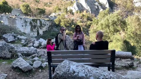 Young multinational tourists standing next to bench in ancient termessos cit Stock Footage 148100740