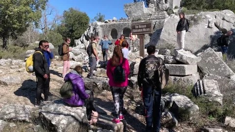 Young multinational tourists talking at ruins of ancient termessos city Stock Footage 148100991