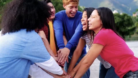 Young multiracial community of friends having fun stacking hands together Video stock 339749775