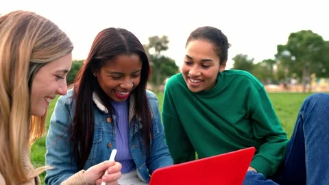 Young multiracial female students working together on laptop at college campus Stock Footage 251666528