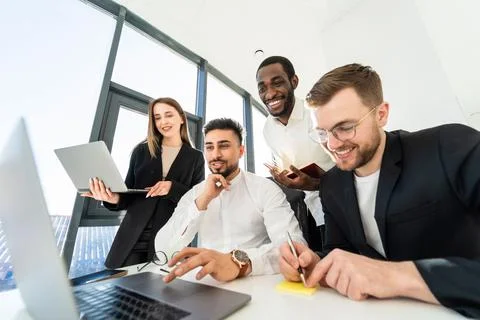 Young multiracial software developers working on laptop together Stock Photos