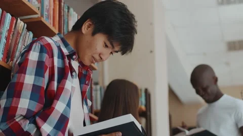 Young multiracial students attentively reading books used in their education Stock Footage 227692528