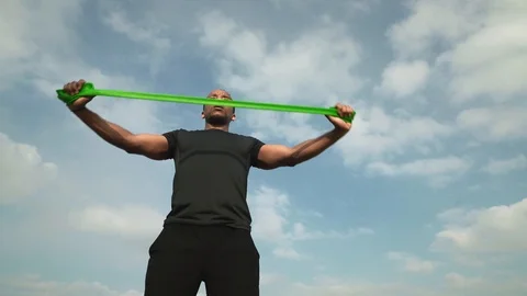Young muscular afro guy training arms with resistance band Stock Footage 121274096