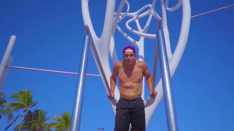 Young muscular guy doing exercise on uneven bars outdoor Stock Footage 108920084