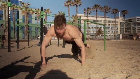 Young muscular man doing functional training on sport ground on beach 動画素材 129990918