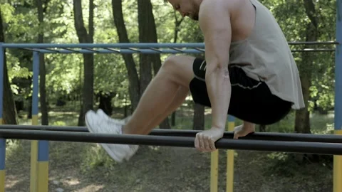 Young muscular man doing press exercise outdoors Stock Footage 130268357