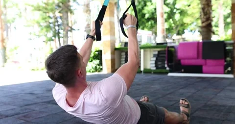Young muscular man doing pull-ups with elastic band outdoors Video stock 288089532