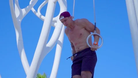 Young muscular man doing pushups exercise on rings outdoor Video stock 108919907