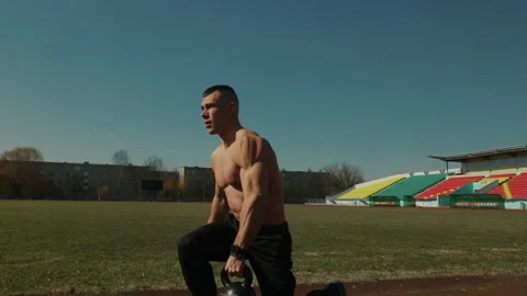 Young muscular man performs strength exercises at city stadium. Concept of Vídeo Stock 274311305