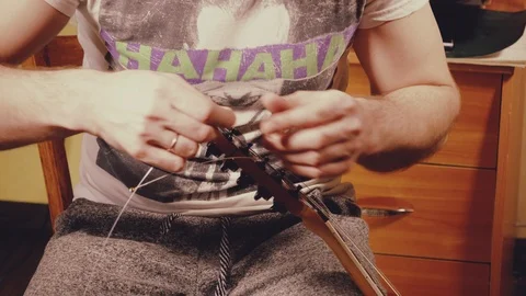 A young musician changes the strings on the guitar Stock Footage 103422649