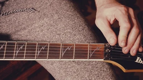 A young musician changes the strings on the guitar Stock Footage 103423043