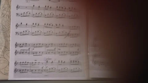 Young musician flips through sheet music playing piano Stock Footage 243785125