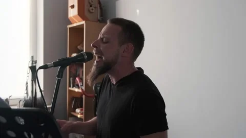Young musician singing into microphone while recording new song at home Stock Footage 133515407