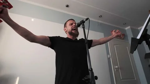 Young musician singing into microphone while recording new song at home Stock Footage 133524201