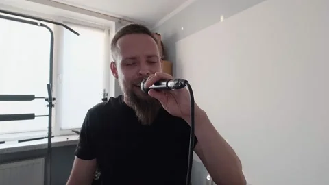 Young musician singing into microphone while recording new song at home Stock Footage 133525209