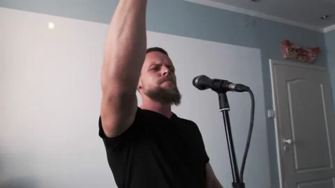 Young musician singing into microphone while recording new song at home Stock Footage 133528419