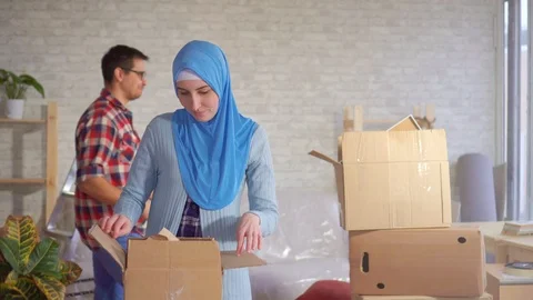 Young muslim couple disassembles boxes after moving Video stock 105376976