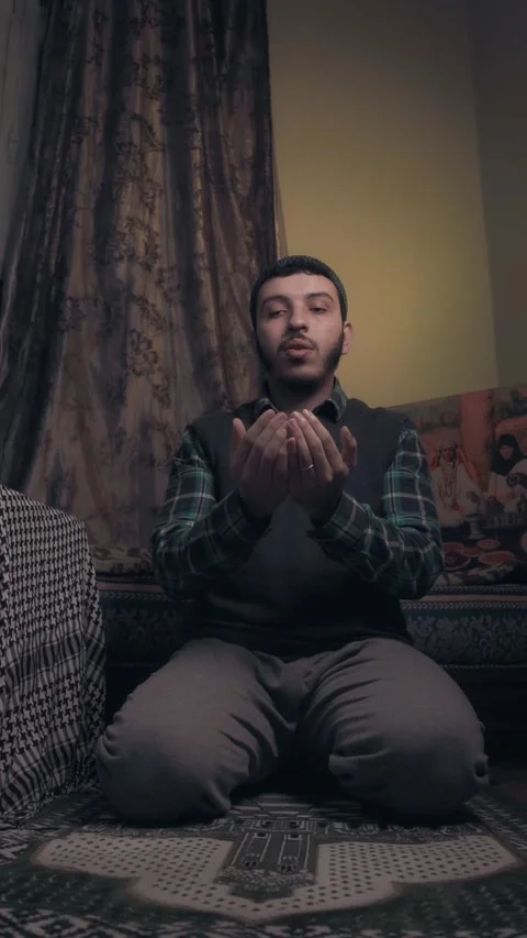 Young Muslim Man Making Sincere Dua Supplication on Prayer Rug at Home Video stock 322790591