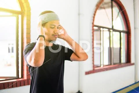 Young muslim man praying hands up for takbir inside a mosque Stock Photos