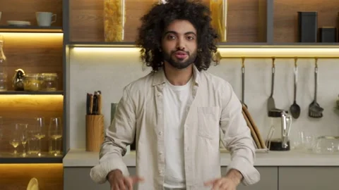 Young Muslim man talks looking in camera standing in kitchen Stock-Footage 169608693