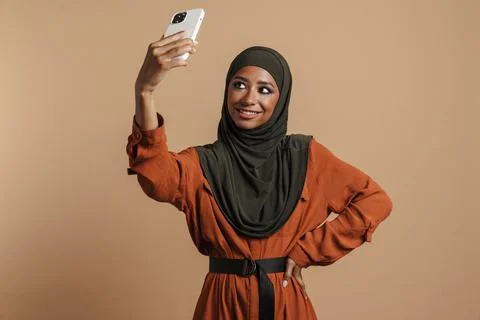 Young muslim woman in hijab taking selfie photo on mobile phone Stock Photos