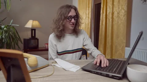 Young nerd 1980s 1990s man using vintage outdated laptop moving hand under table Stock Footage 151361920