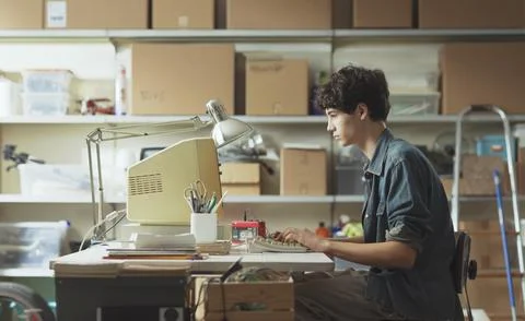 Young nerd guy working with a vintage computer 스톡 사진