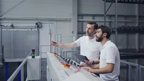 Young new employee training machine operation and talking with factory floor Stock Footage 108450287