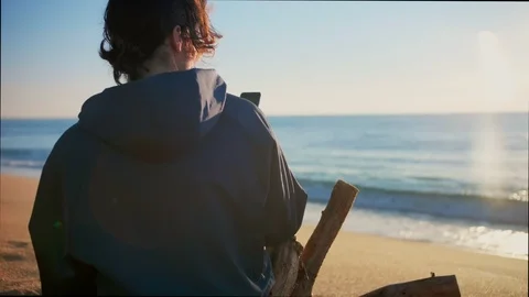 Young nostalgic man making smartphone camera picture of sunrise or sunset ocean Stock Footage 100898631