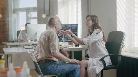 Young nurse checks groping thyroid gland of patient old men Stock Footage 93937661