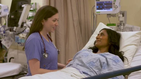 A young nurse performs a patient evaluation to get her vital signs. Stock Footage 77736098