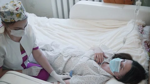 A young nurse puts a drip Stock Footage 147023702