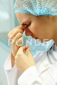 A young nurse rubbing her nose Stock Photos