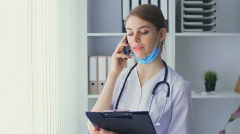 The young nurse speaks by phone Video stock 59220093