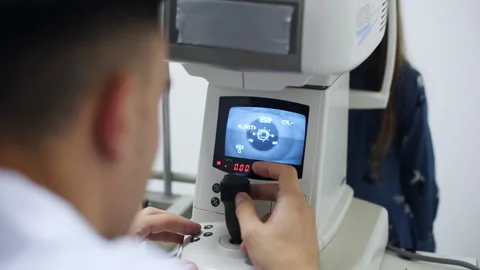 Young oculist in white coat using special device with display Video stock 304981232
