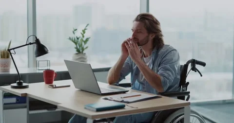Young office executive handsome disabled male worker in wheelchair sitting by Stock Footage 149181314