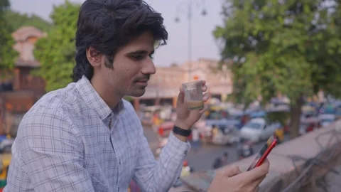 A young office man using phone while taking a sip of a milk tea Stock Footage 147642832
