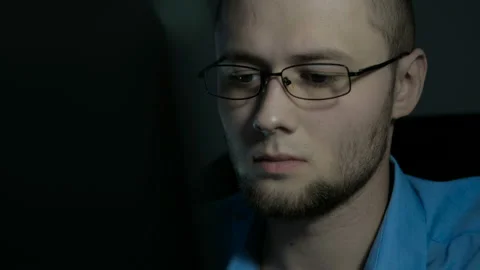Young office worker in glasses typeing on a laptop. Man tired after work Stock Footage 88996540