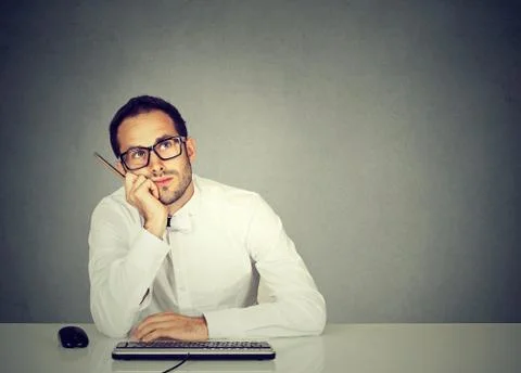 Young office worker sitting at table dreaming Stock Photos