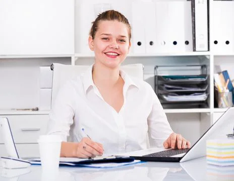Young office worker is working with documents and laptop Stock Photos