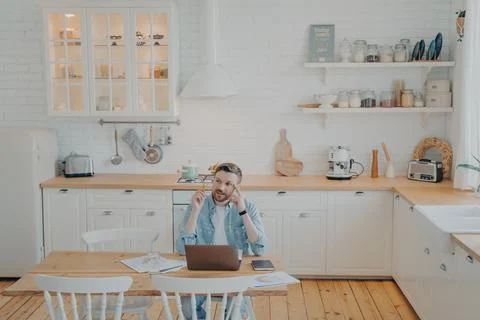 Young office worker working remotely from home with computer while sitting by Foto stock