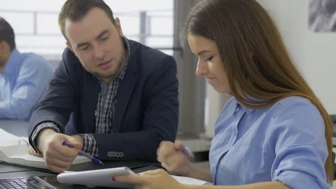 Young office workers discussing the data in the documents Stock Footage 73991025