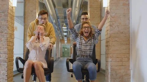 Young Office Workers Having Fun and Riding Chairs on Break Vidéo 126135365